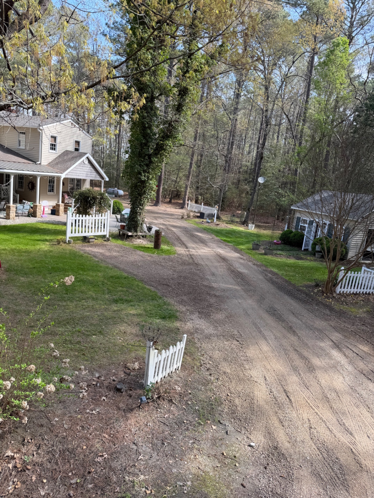 Residential gravel driveway after grading work near a home and detached building